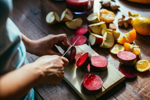 woman's hands chopping beetroot for squeezing juice - food stock pictures, royalty-free photos & images