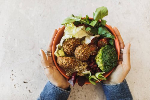 woman's hands holding bowl with falafel, broccoli, greens, cherry tomatoes, red beans, beetroot and quinoa - junk food stock pictures, royalty-free photos & images