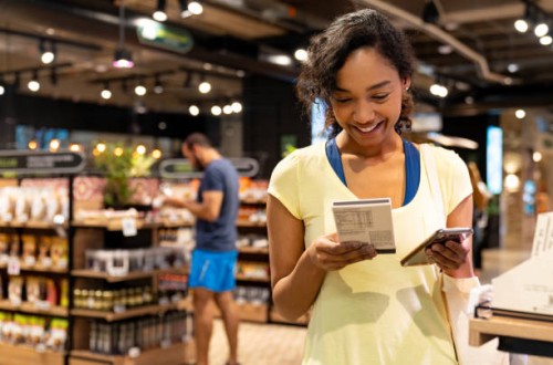 woman scanning the nutrition label on a product at the supermarket - food stock pictures, royalty-free photos & images
