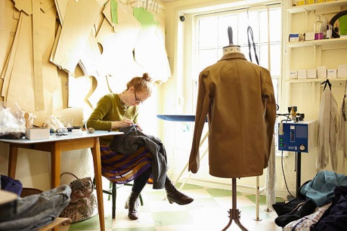 woman sewing in clothing manufacturer's workshop - fashion stock pictures, royalty-free photos & images