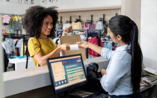 woman shopping at a clothing store and paying to the cashier - fashion stock pictures, royalty-free photos & images
