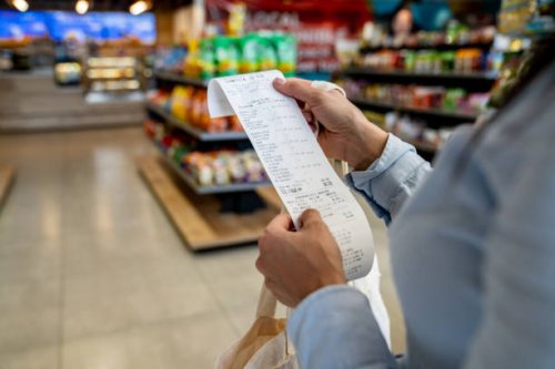 woman shopping at a convenience store and checking her receipt - food stock pictures, royalty-free photos & images
