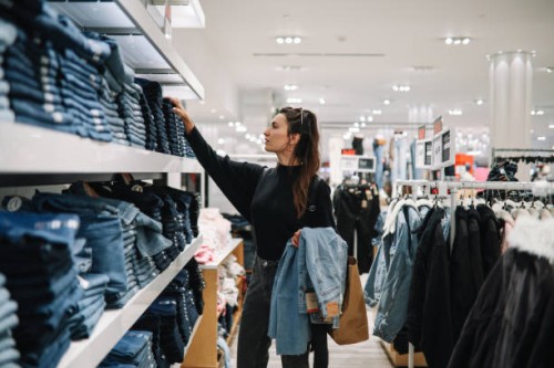 woman shopping denim jeans in a clothing store - fashion stock pictures, royalty-free photos & images