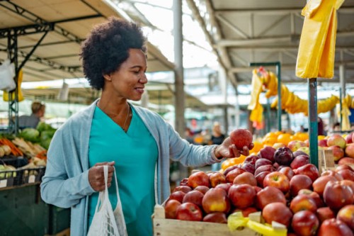woman shopping for fresh organic fruits in farmers market with a eco bag. - food stockfoto's en -beelden