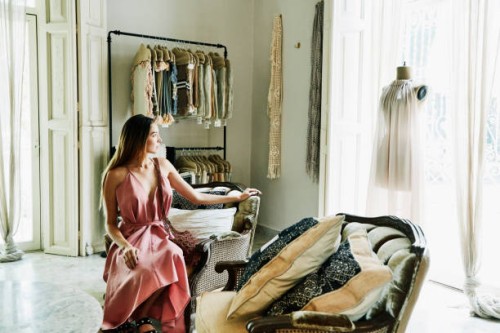 woman sitting in boutique admiring dress on mannequin in window - fashion stock pictures, royalty-free photos & images
