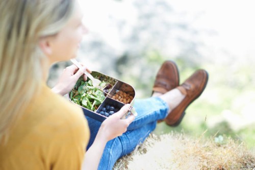 woman sitting in countryside eating healthy plastic free lunch. - junk food stock pictures, royalty-free photos & images