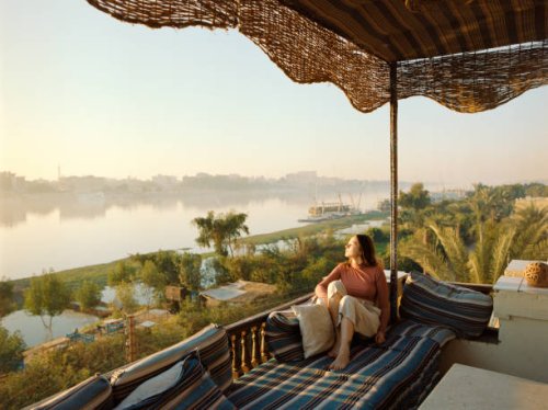 woman sitting on terrace and looking at nile at sunset in luxor - travel stock pictures, royalty-free photos & images