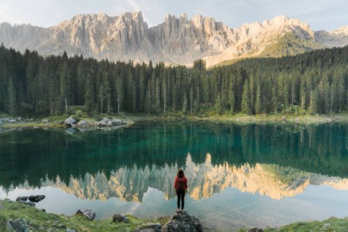 woman standing and looking at lago di carezza in dolomites - travel stock pictures, royalty-free photos & images