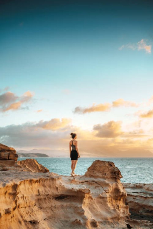 woman standing on a cliff overlooking spectacular sunset - travel stock pictures, royalty-free photos & images