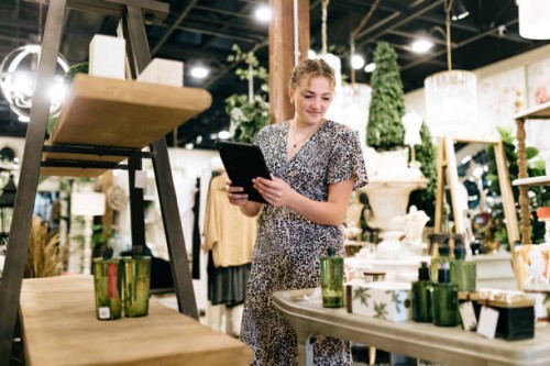 woman stocks shelves at home retail store - home decoration stockfoto's en -beelden