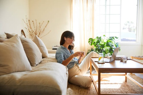 woman streaming something on a laptop in her living room - home decoration stock pictures, royalty-free photos & images