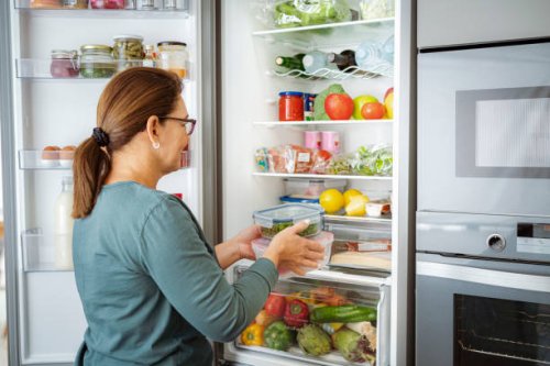 woman takes containers with raw food from fridge - food stock pictures, royalty-free photos & images