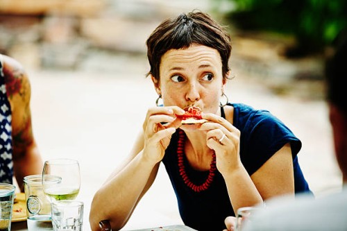 woman taking bite of pizza during backyard dinner - food stock pictures, royalty-free photos & images