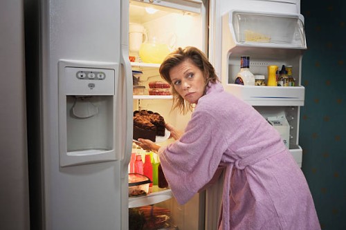 woman taking cake out of refrigerator - junk food stock pictures, royalty-free photos & images