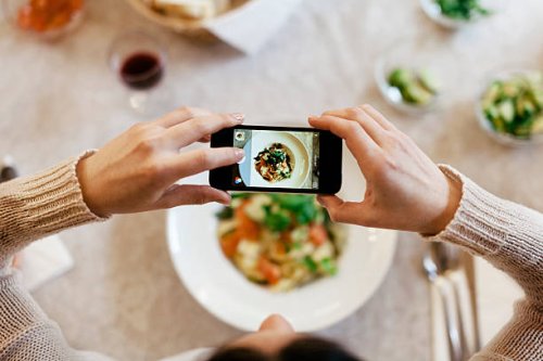 woman taking overhead photo of dinner - food stock pictures, royalty-free photos & images