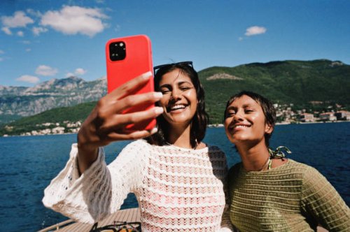 woman taking selfie with female friend on smart phone - travel stock pictures, royalty-free photos & images