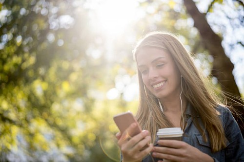 woman texting on her phone at the park - junk food stock pictures, royalty-free photos & images
