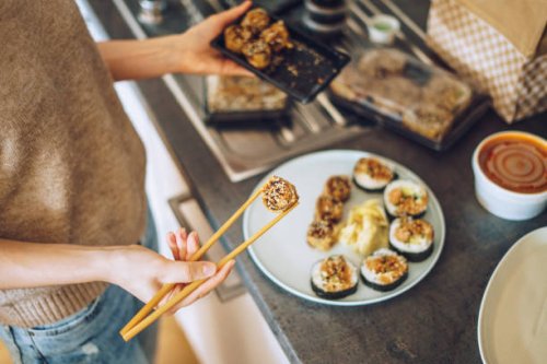 woman unpacking takeaway sushi at home - junk food stock pictures, royalty-free photos & images