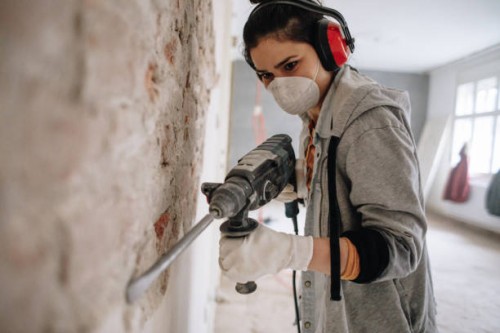 woman using drilling machine during reconstruction of her apartment - home decoration stock pictures, royalty-free photos & images