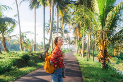 woman walking in coconut tree grove on bali - travel stock pictures, royalty-free photos & images