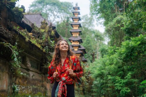 woman walking past the temple in the jungles in bali - travel stock-fotos und bilder