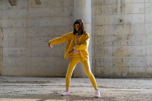 woman wearing yellow jeans clothes, dancing - fashion stock pictures, royalty-free photos & images
