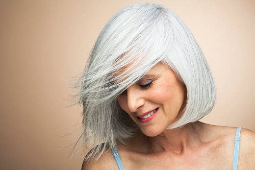 woman with a silvery,grey bob looking down. - hairstyle stock-fotos und bilder