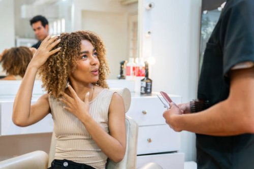 woman with curly hair telling her hairstylist how to cut her hair - hairstyle stock pictures, royalty-free photos & images