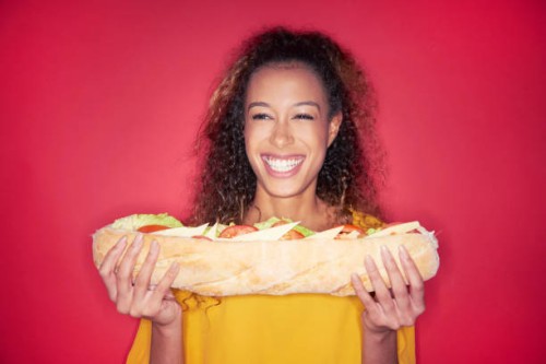 woman with giant sandwich - junk food stock-fotos und bilder