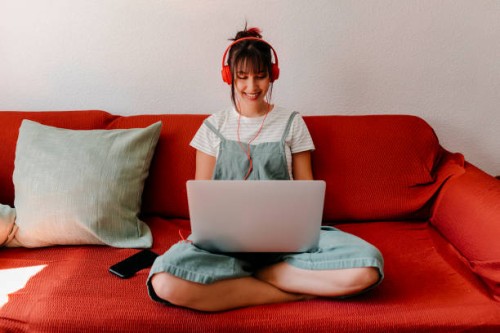 woman with headphones working on laptop in living room - home decoration stock pictures, royalty-free photos & images