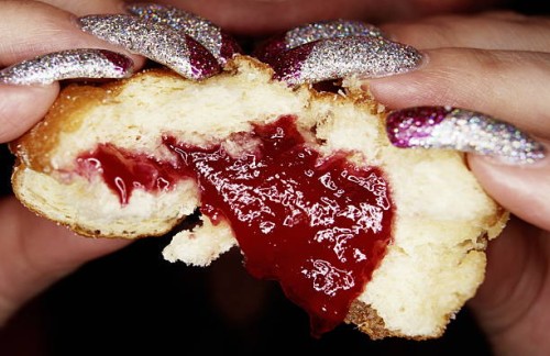 woman with long glittery nails eating jam doughnut, close-up - food stock pictures, royalty-free photos & images