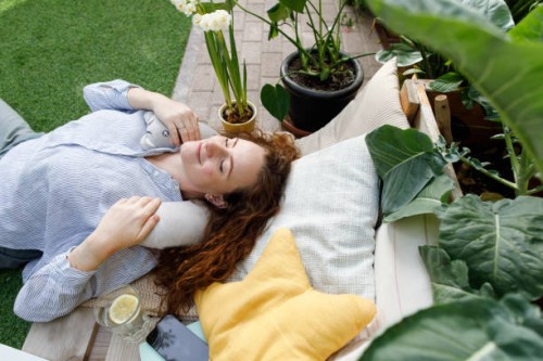 woman with neck pillow lying at backyard - garden decoration photos et images de collection