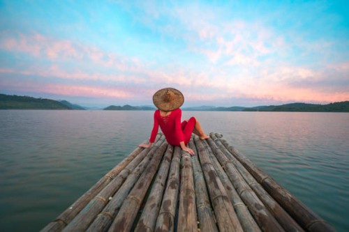woman with red dress and traditional hat sitting on a wooden raft - travel stock pictures, royalty-free photos & images