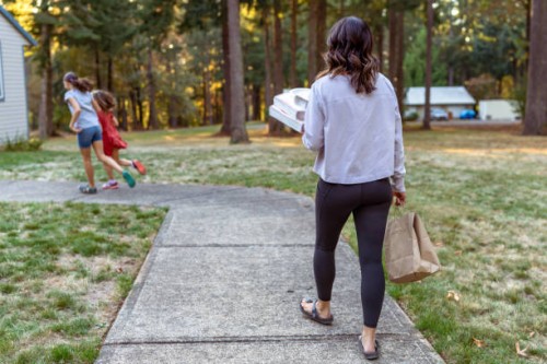 woman with two kids carrying takeout pizza into her home - junk food stock pictures, royalty-free photos & images