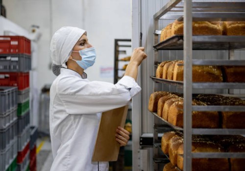 woman working at an industrial bakery and doing quality control on the loafs of bread - food stock pictures, royalty-free photos & images