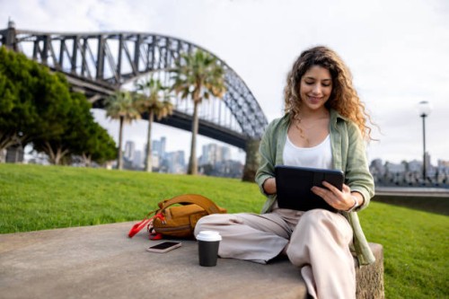 woman working outdoors on her tablet in sydney while drinking coffee - junk food stock pictures, royalty-free photos & images