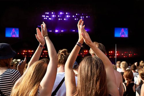women clapping hands at big concert - concert stock pictures, royalty-free photos & images