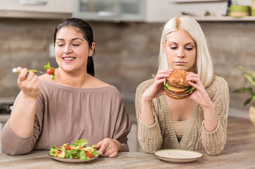 women eating in the kitchen. - junk food stock pictures, royalty-free photos & images