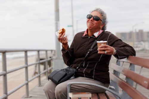women eating pastry and drinking coffee on boardwalk - junk food stock pictures, royalty-free photos & images