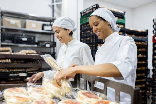women working at an industrial bakery doing quality control on packages of bread - food stock pictures, royalty-free photos & images