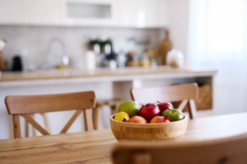 wooden bowl of fresh fruits is standing on a dining table in a modern kitchen - home decoration stock pictures, royalty-free photos & images