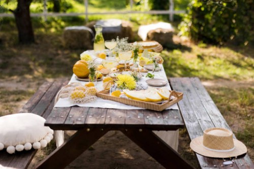 wooden picnic table decorated with various food in garden - garden decoration stock pictures, royalty-free photos & images