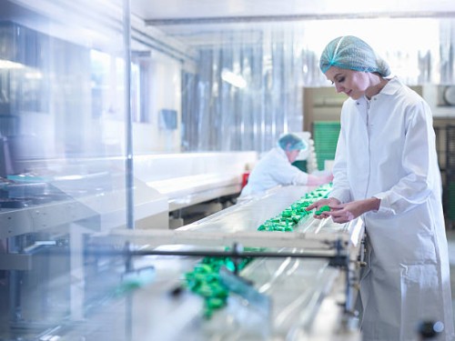 worker inspecting chocolate on production line in chocolate factory - food stock pictures, royalty-free photos & images