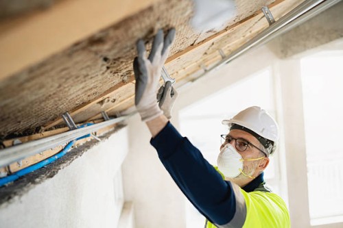 worker installing roof insulation in construction site with safety equipment - home decoration stock pictures, royalty-free photos & images