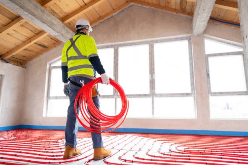 worker installing underfloor heating system with red pipes in new building - home decoration stock pictures, royalty-free photos & images