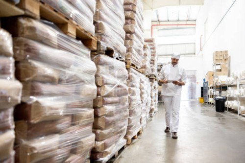 worker taking inventory of the flour at an industrial bakery - food stock pictures, royalty-free photos & images