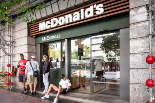 Workers from the Spanish start-up on-demand delivery company, Glovo, wait at the American multinational fast-food hamburger restaurant chain,...