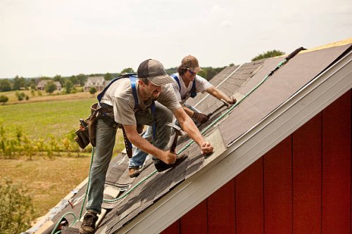 workman install roof on rural building - home decoration stock pictures, royalty-free photos & images