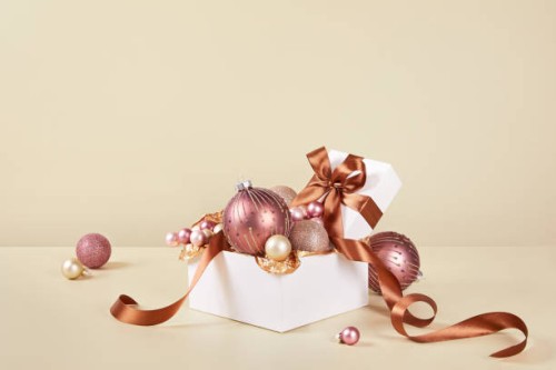 xmas still life composition with pastel pink christmas ornaments on solid beige background - home decoration stockfoto's en -beelden