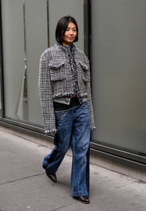 Yan Yan Chan is seen wearing a gray tweed Sacai jacket, blue Sacai jeans and black shoes outside the Sacai show during Womenswear Spring/Summer 2025...